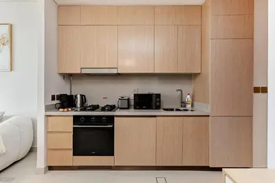a kitchen with wooden cabinets and a stove at Vida Dubai Mall Connected 1BR in Dubai