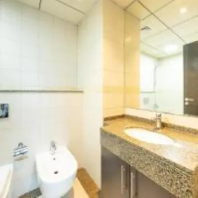 a bathroom with a sink and a toilet and a mirror at Bay View in Marina Bay in Dubai