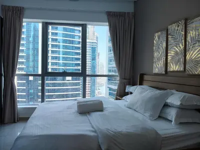 a bedroom with a large bed with a large window at Bay View in Marina Bay in Dubai