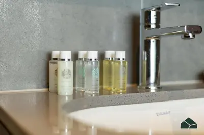 four bottles of moisturizers sitting on a counter next to a sink at Stylish 1BR with City and Partial Burj View by BMS in Dubai