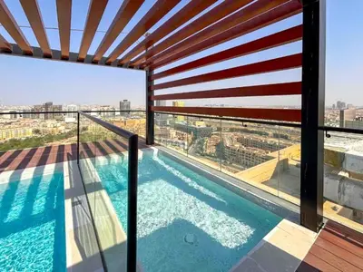 a balcony with a swimming pool on a building at Studio with Community Views, Easy Access to Bus Stop, Parks, and Circle Mall, Empire Residence, JVC by Deluxe Holiday Homes in Dubai