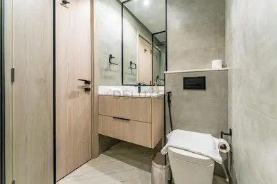 a bathroom with a toilet and a sink and a mirror at Studio with Community Views, Easy Access to Bus Stop, Parks, and Circle Mall, Empire Residence, JVC by Deluxe Holiday Homes in Dubai