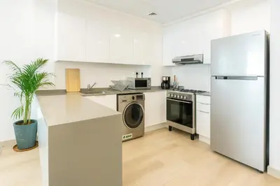 a kitchen with a refrigerator and a washing machine at Resort lifestyle, Fantastic Views, Bright & Brand new in Dubai