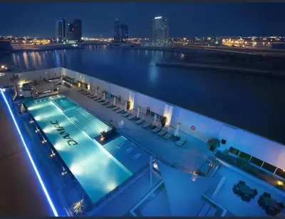 a swimming pool on top of a building at night at Damac Maison Canal Views, Luxury Waterfront Apartment, 2 BR, Dedicated Office, Sleeps 6 in Dubai