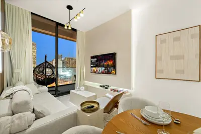 a living room with a couch and a table at Bright & Cozy 1BR Apartment with Balcony in JVC in Dubai