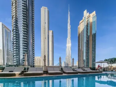 a pool with chaise lounge chairs and buildings at Brand new 2BR in Downtown 5 min walk to Burj Khalifa in Dubai