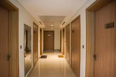 an empty hallway in a building with wooden doors at New Studio in Meydan With Pool & Gym in Dubai