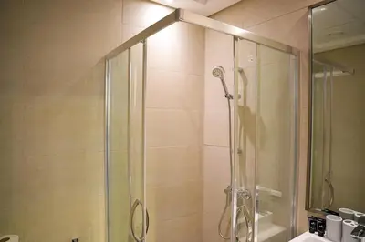 a shower with a glass door in a bathroom at New Studio in Meydan With Pool & Gym in Dubai
