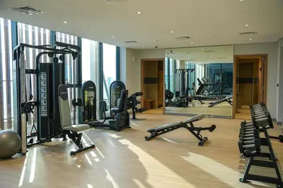 a gym with several treadmills and machines in a building at New Studio in Meydan With Pool & Gym in Dubai