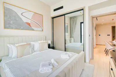 a bedroom with a large white bed and a mirror at PVH - Binghatti Heights - Urban Luxury 3BR in Dubai