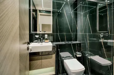 a bathroom with a sink and a toilet and a mirror at PVH - Binghatti Heights - Urban Luxury 3BR in Dubai