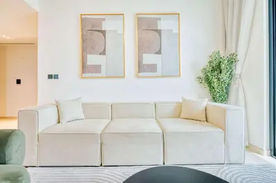 a living room with a white couch and two paintings at PVH - Binghatti Heights - Urban Luxury 3BR in Dubai