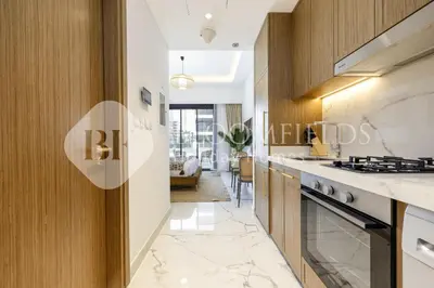 a kitchen with white counters and a stove top oven at Bloomfields Elegant Stu in Azizi Rivera in Dubai