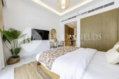 a bedroom with a large bed and a table at Bloomfields Elegant Stu in Azizi Rivera in Dubai