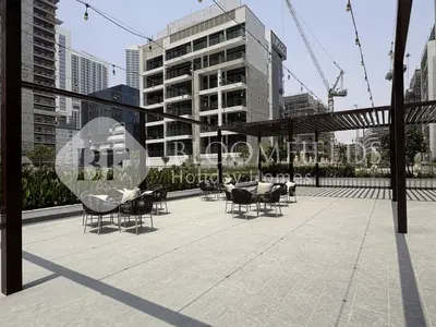 a patio with chairs and tables in a city at Bloomfields Elegant Stu in Azizi Rivera in Dubai