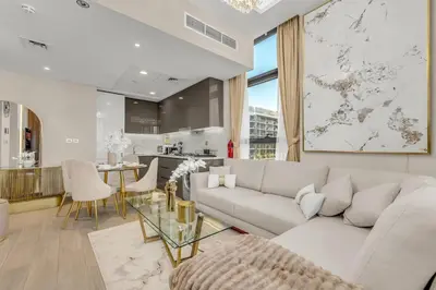 a living room with a white couch and a table at Stylish 1BR with Pool Gym and Parking in Riviera 12 in Dubai