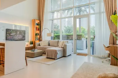 a living room with a couch and a large window at Homely Creek Harbour Apartment - Direct Park Access in Dubai