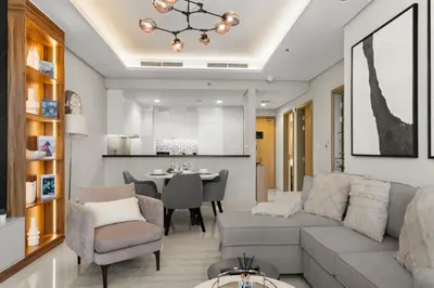 a living room with a couch and a dining room at Gogoto4 - 2BR High Floor Burj View Infinity Pool PS5 NYE Fireworks View in Dubai