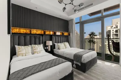 a bedroom with two beds and a large window at Gogoto4 - 2BR High Floor Burj View Infinity Pool PS5 NYE Fireworks View in Dubai