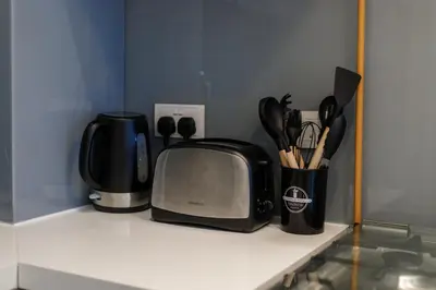 a kitchen counter with a coffee maker and a microwave at Modern House with Huge Private Garden in JVC in Dubai