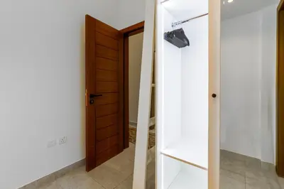 a hallway with a wooden door and a shelf at Modern House with Huge Private Garden in JVC in Dubai