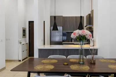 a kitchen with a wooden table with a vase of flowers at Modern House with Huge Private Garden in JVC in Dubai