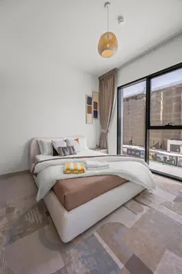 a bedroom with a large bed and a large window at Luxury 1BR Apartment Dubai in Dubai