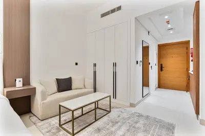 a living room with a couch and a table at Chic Studio APT with Pool & Gym - Near Metro Station in Dubai