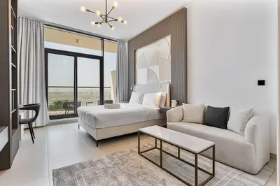 a bedroom with a bed and a couch and a table at Chic Studio APT with Pool & Gym - Near Metro Station in Dubai