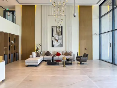 a large living room with a couch and chairs at Chic Studio APT with Pool & Gym - Near Metro Station in Dubai