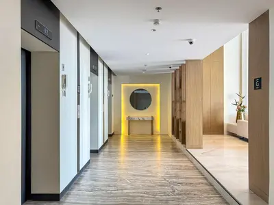 a hallway of an office with yellow walls and wooden walls at Chic Studio APT with Pool & Gym - Near Metro Station in Dubai