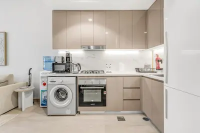 a kitchen with a washing machine and a washer at Stylish Apartments in a Vibrant Community in Dubai