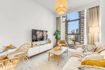 a living room with a couch and a tv at Stylish Apartments in a Vibrant Community in Dubai