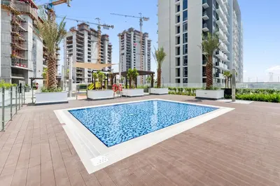 a swimming pool in a building with tall buildings at Cozy Downtown Studio Dubai Retreat in Dubai