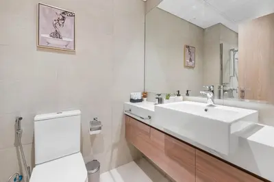a bathroom with a white sink and a toilet at Cozy Downtown Studio Dubai Retreat in Dubai