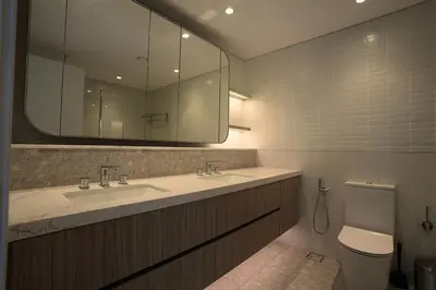 a bathroom with a sink and a toilet and a mirror at Spacious 3BR in Sobha Hartland near Downtown in Dubai