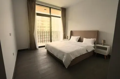 a bedroom with a bed and a large window at Spacious 3BR in Sobha Hartland near Downtown in Dubai