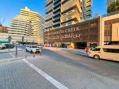 a city street with cars parked in front of buildings at 1 Bedroom Dream Stay- Binghatti in Dubai