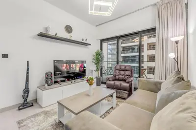 a living room with a couch and a tv at 1 Bedroom Dream Stay- Binghatti in Dubai