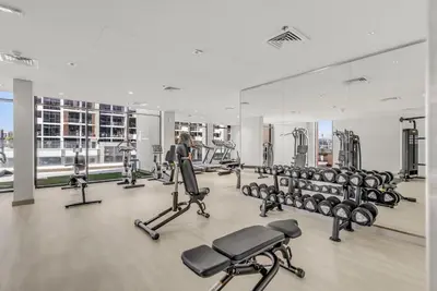 a gym with rows of treadmills and machines at 1-Bedroom Oasis with Views in Dubai