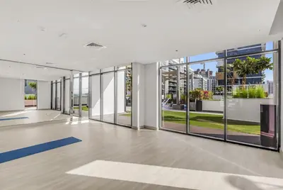 an empty office with large windows and a large room with yoga mats at 1-Bedroom Oasis with Views in Dubai