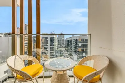 a balcony with a table and chairs and a view of a city at 1-Bedroom Oasis with Views in Dubai