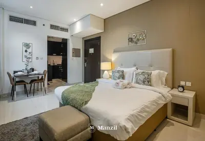 a bedroom with a large bed and a dining room at Luxury Studio close to Dubai Mall and Burj Khalifa in Dubai