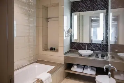 a bathroom with a tub and a sink and a shower at Stylish 1BR in Damac by Paramount Business Bay in Dubai
