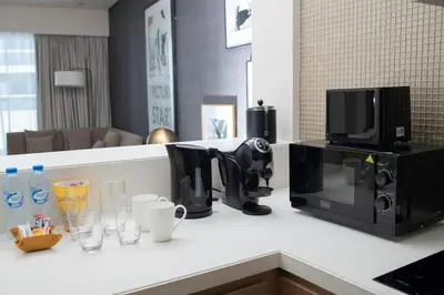 a kitchen counter with a coffee maker and a microwave at Stylish 1BR in Damac by Paramount Business Bay in Dubai