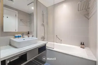 a white bathroom with a sink and a shower at Waterfront Studio in Business Bay near Burj Khalifa in Dubai