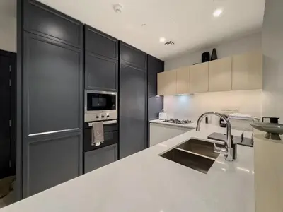 a kitchen with black cabinets and a white counter top at Amazing Brand New 1BR in Dubai