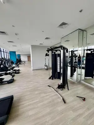 a gym with rows of treadmills and elliptical machines at Stylish City Studio with Burj Khalifa View in Dubai