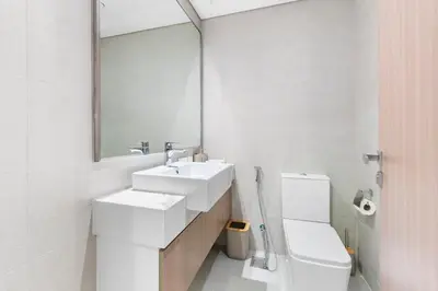 a bathroom with a sink and a toilet and a mirror at Stylish City Studio with Burj Khalifa View in Dubai