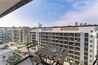 a balcony with a wooden table on top of a building at Stylish City Studio with Burj Khalifa View in Dubai